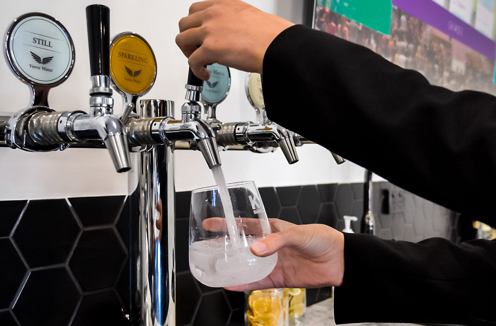 KJ Barbers pouring chilled sparkling water on tap with dehydrated citrus